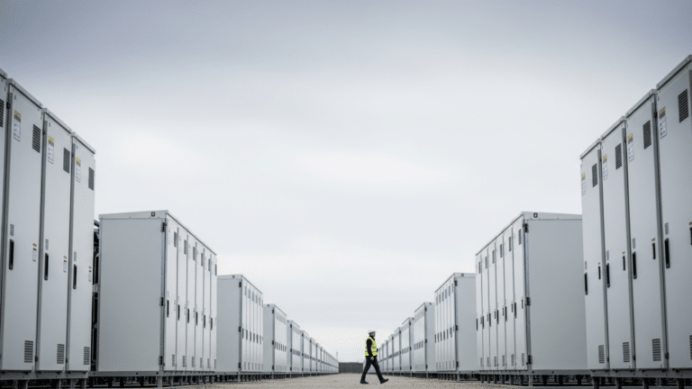 Rows of utility-scale battery storage enclosures under overcast sky, battery storage record