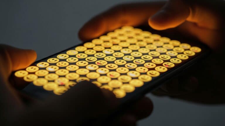 Hands holding a smartphone displaying Noto 3D emoji on screen, google rebuilds
