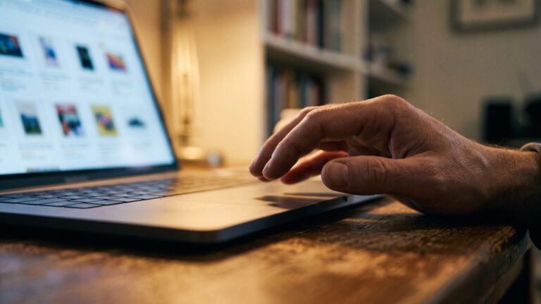 Hands scrolling a commercial product webpage on a laptop showing AI authorship content
