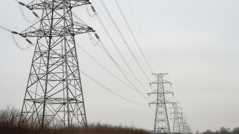High-voltage transmission towers under overcast sky illustrating grid load growth, doe draft