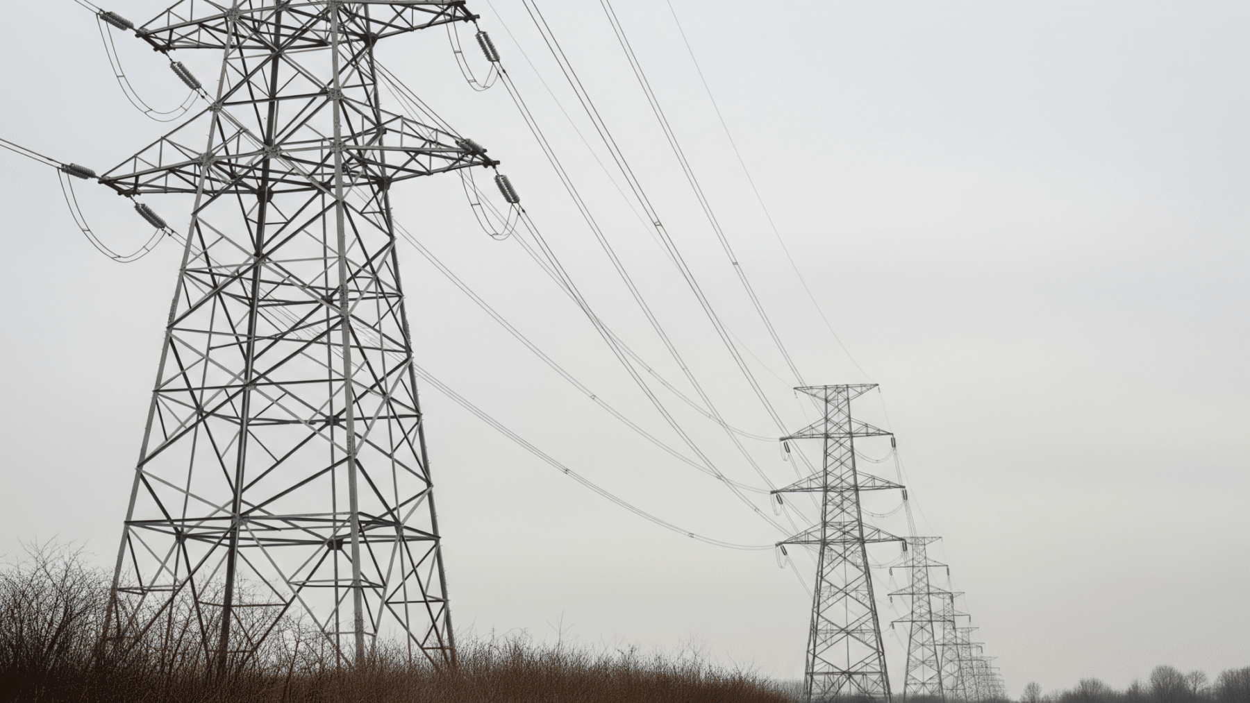 High-voltage transmission towers under overcast sky illustrating grid load growth, doe draft