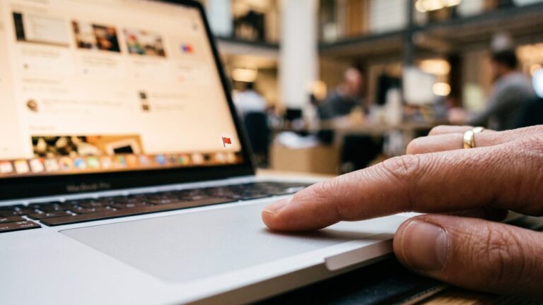 hands scrolling a laptop screen using LinkedIn AI slop reporting tool, linkedin s