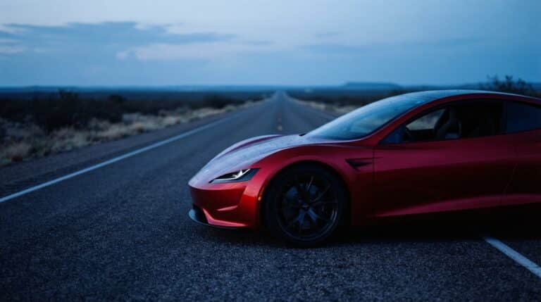 Low-angle view of a sleek red Tesla Roadster electric sports car on a Texas highway, tesla set