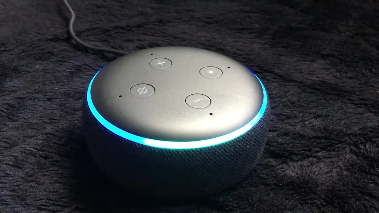 Amazon Echo smart speaker with LED ring on a wooden desk, amazon s