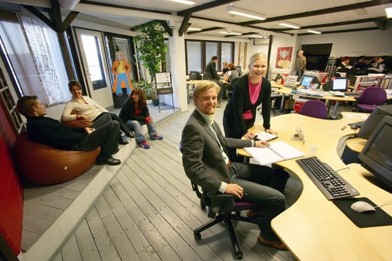Empty office desks with blurred workers, illustrating daily office rudeness cost