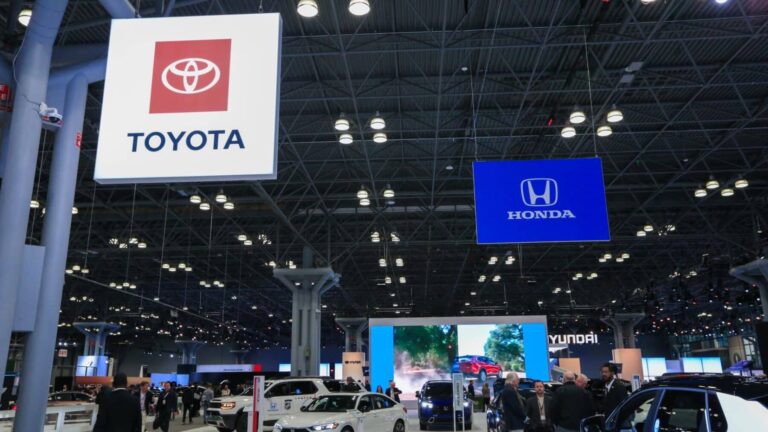 Hand connecting EV charging cable as automakers roll out EV rebates