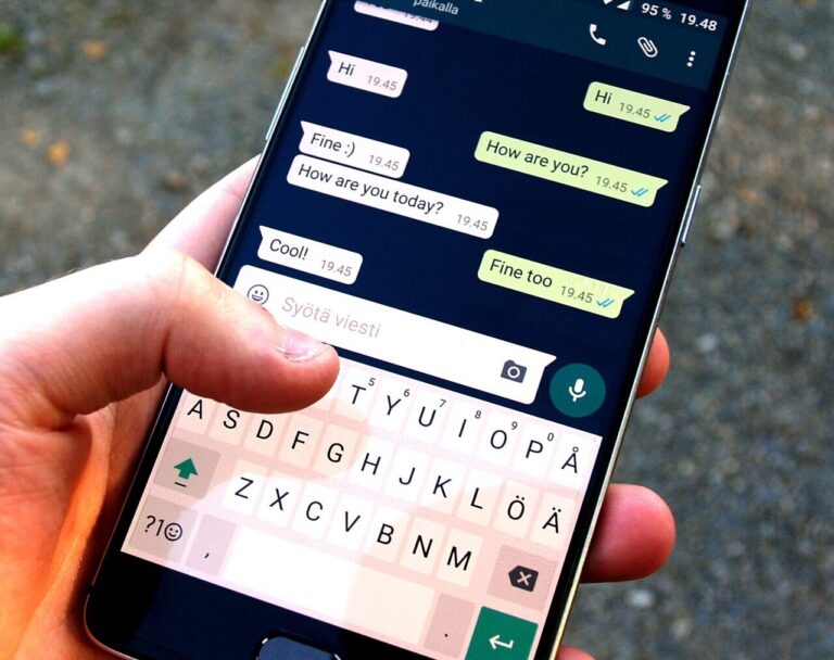 Hand holding smartphone showing WhatsApp Plus subscription chat screen, free messaging