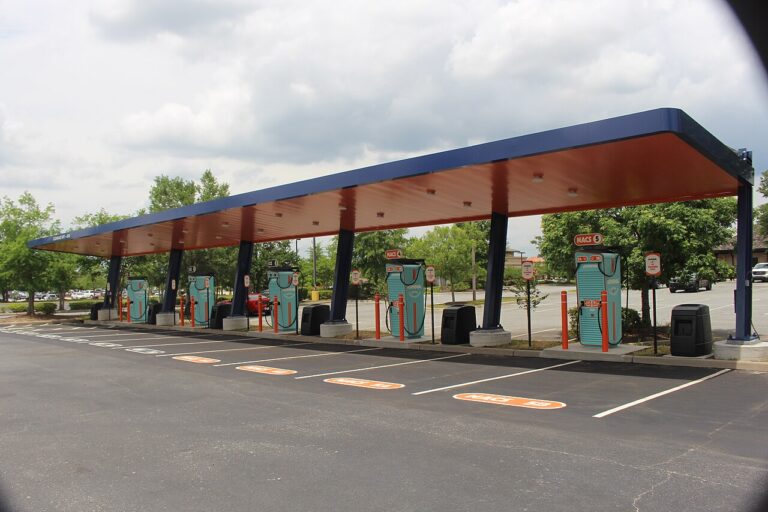 Row of DC fast-charging stalls at a public charging station at dusk