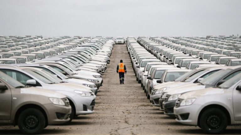 Rows of unsold cars on a dealer storage lot, incentive discount war, major us