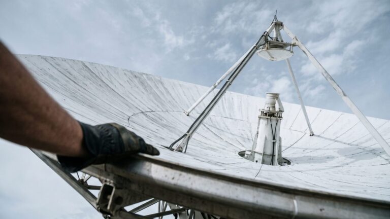 Satellite dish antenna under overcast sky illustrating satellite spectrum story, satellite power