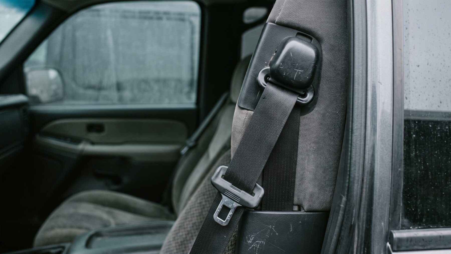 Locked seat belt pretensioner retractor inside a full-size SUV B-pillar