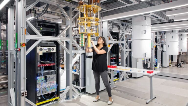 Superconducting quantum processor chip inside a cryogenic refrigerator under cold lab light, spacetime pec