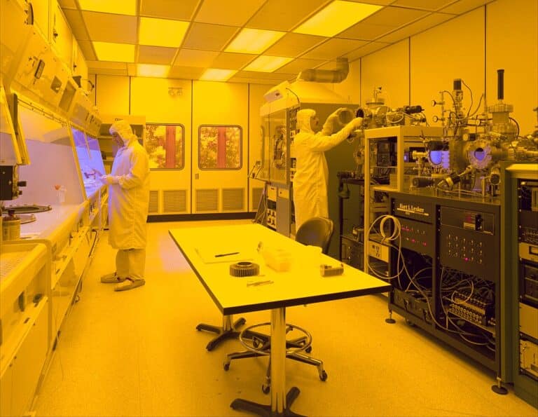 Gloved hands holding an automotive chips supply chain semiconductor component, acea study