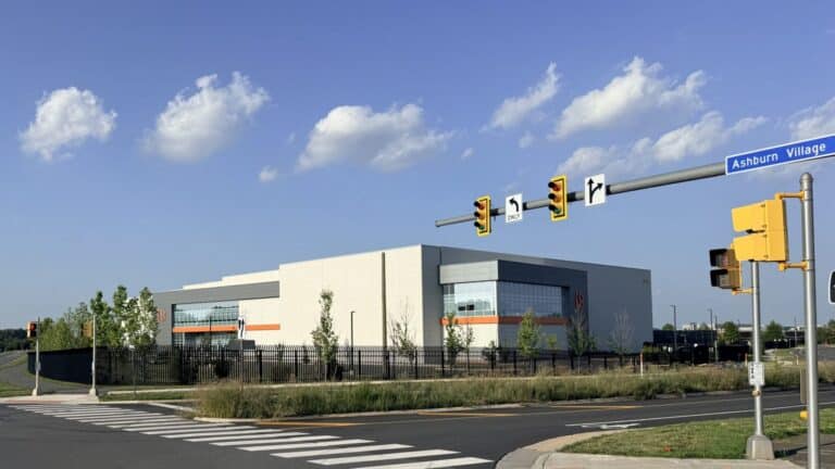 Data center buildings near a small community at dusk, aws pledges