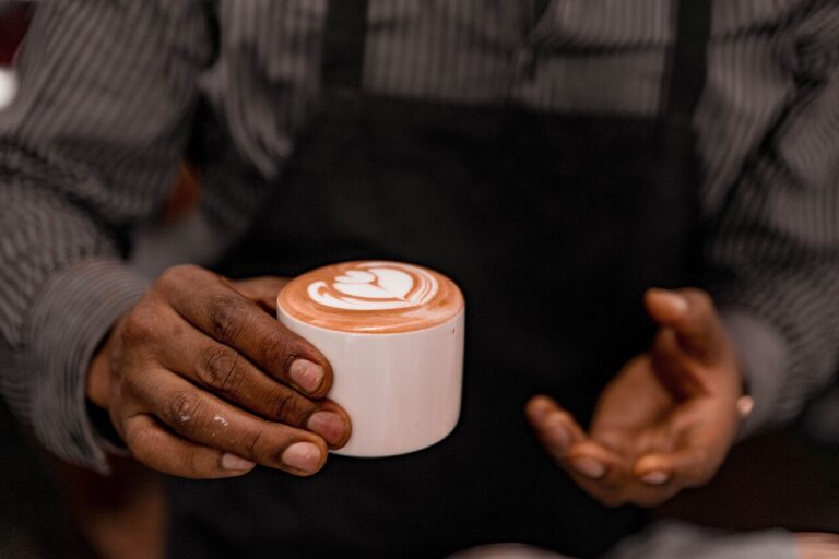 Coworkers chatting near office coffee machine during small talk break