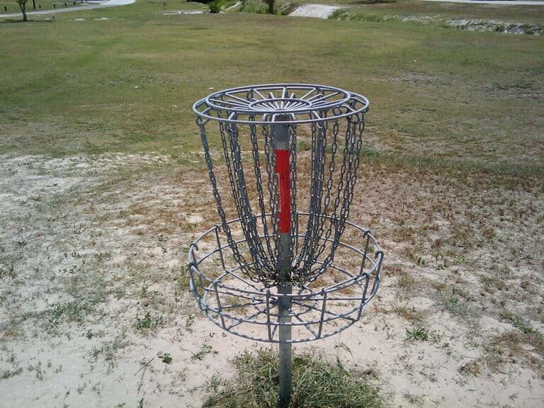 Disc golf basket and chains standing in a public park fairway