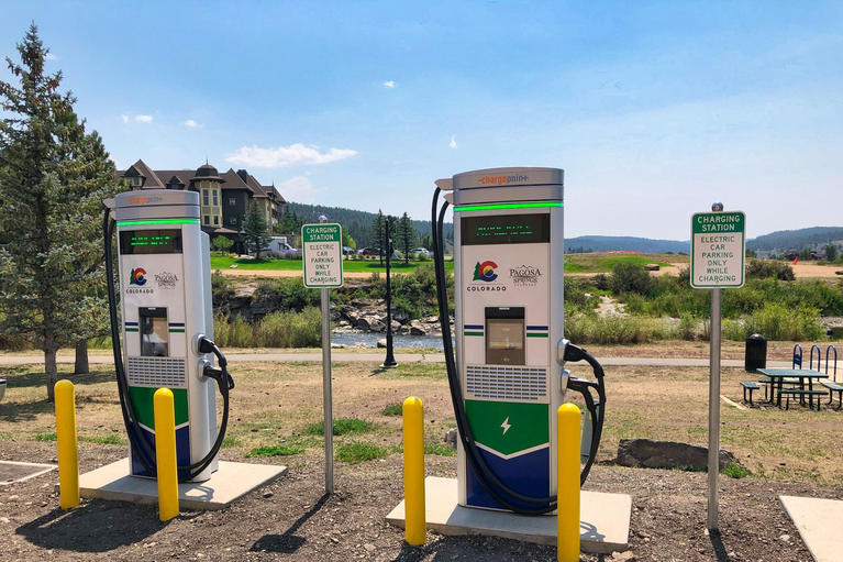Row of fast charging stalls illustrating new Tesla Superchargers network