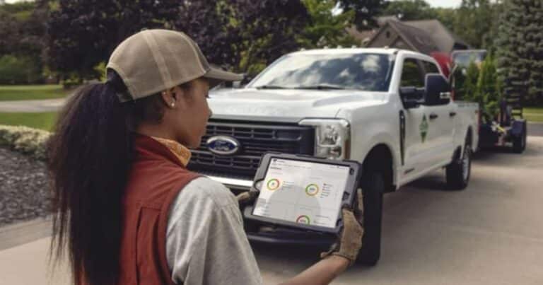 Fleet manager tablet shows truck speed limiter dashboard at depot