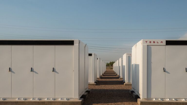 Rows of utility-scale battery containers at a desert grid battery installation site, grid battery installations