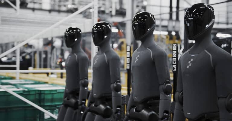 Humanoid robot pulling parts cart inside a car assembly plant