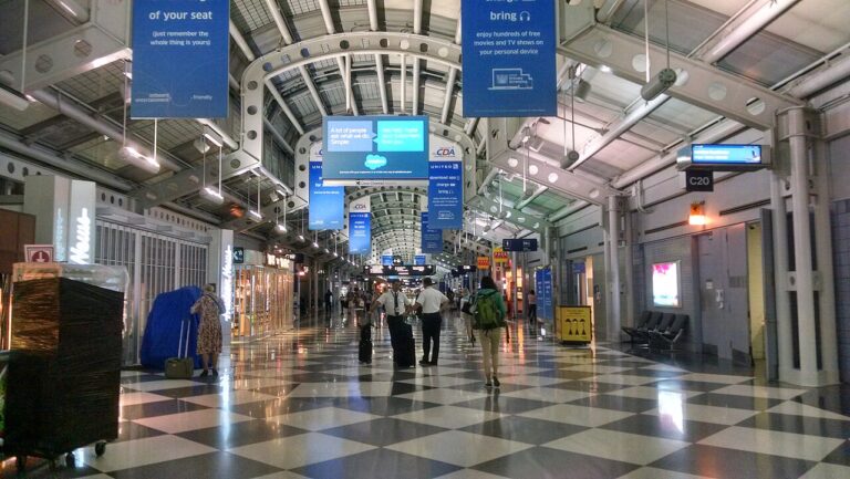 Empty airport departure hall with a suitcase in the foreground, illustrating declining summer vacation rate