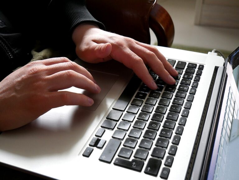 Hand hovering over laptop cart abandonment shopping cart screen, shopper adds