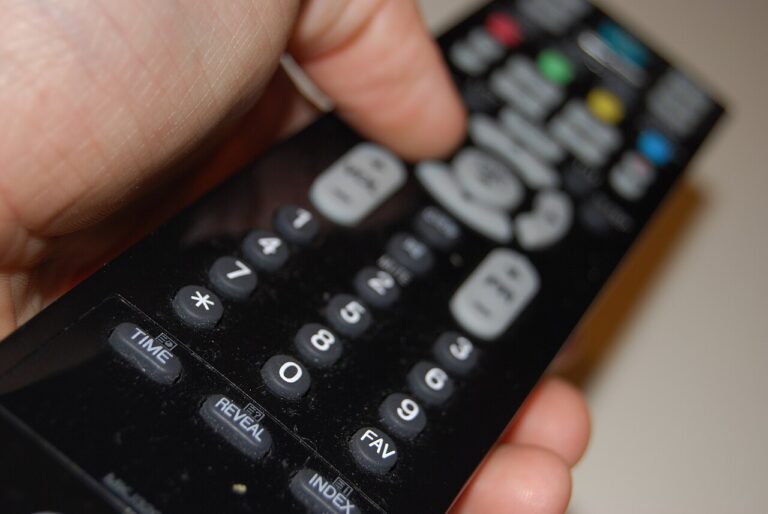 Living room television glowing during a streaming app broadcast at dusk