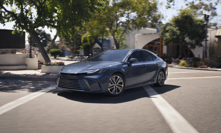 Silver 2027 Camry hybrid sedan on dealership showroom floor